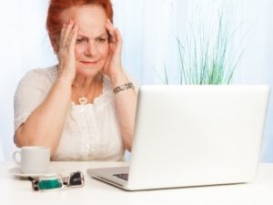 Confused elderly woman dealing with her banking affairs